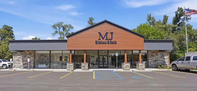 MJ Kitchen & Bath showroom building with a wood-clad gable and stone front at 620 Ann Arbor Rd, Plymouth, MI