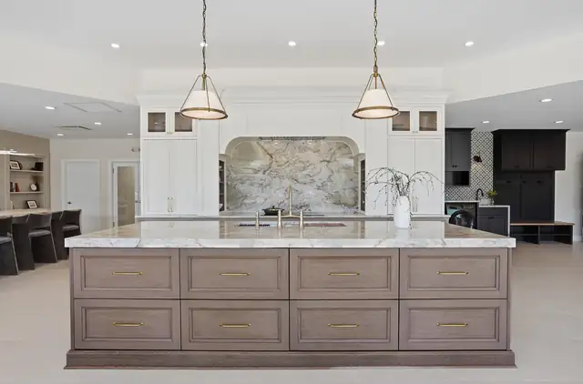 Wood-Mode cabinetry display with a stone backsplash inside the MJ Kitchen & Bath showroom at 620 Ann Arbor Road, Plymouth