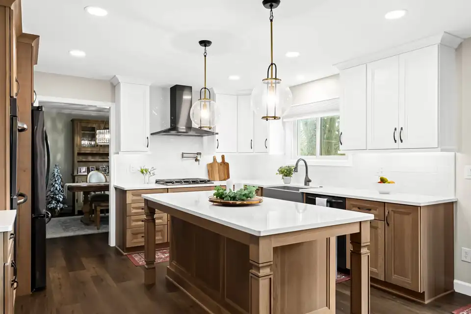 Kitchen remodeling in Plymouth, MI: stained wood base cabinets and island under white painted upper cabinets, by MJ Kitchen & Bath