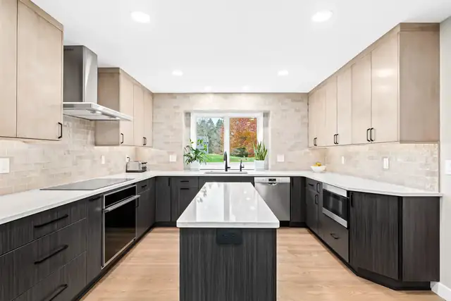 Ann Arbor, MI kitchen with light wood upper cabinets, dark lower cabinets and a center island in a U-shaped layout