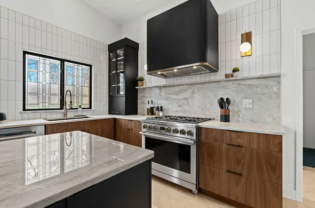 Mid-century kitchen makeover with a black range hood, wood lower cabinets, marble-look backsplash and a leaded glass window